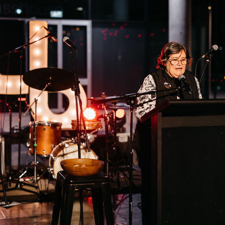 Aunty Colleen speaking at lectern on La Boite stage. Image credit: Markus Ravik