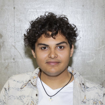 Man with short brown curly hair smiling at camera