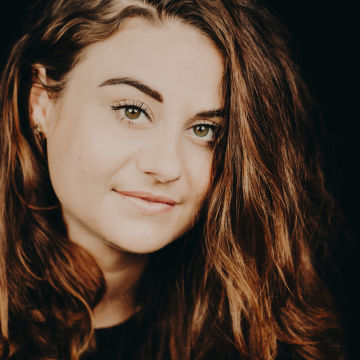 close up of woman with long auburn smiling to camera