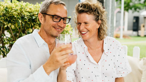 Man and woman sitting together drinking cocktails