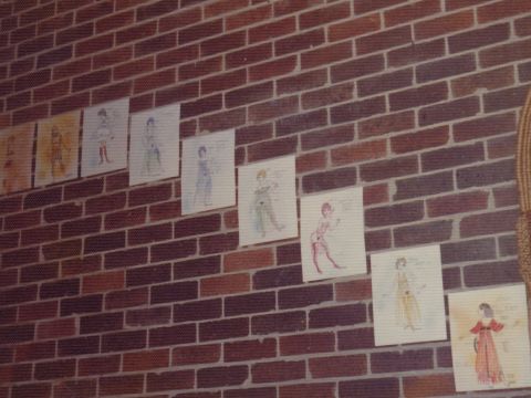 Lysistrata costume designs by Max Hurley on the staircase wall leading into the performance space.